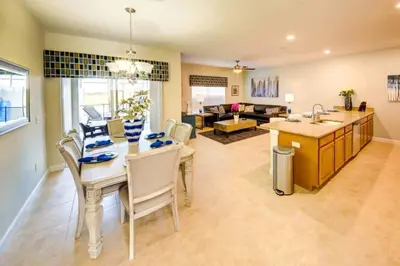 a kitchen and living room with a table and chairs at Storey Lake 4b3b town home with private pool in Kissimmee