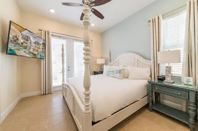 a bedroom with a white bed and a ceiling fan at Cozy Cottage With Hot Tub Near Disney With Margaritaville Resort & Island H2O Access - 8056Dr in Orlando