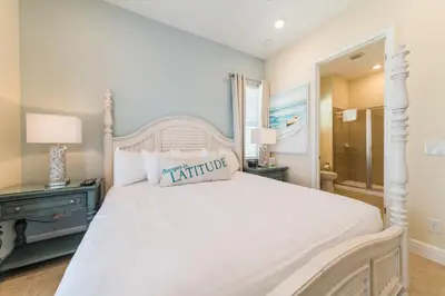 a bedroom with a white bed and a mirror at Cozy Cottage With Hot Tub Near Disney With Margaritaville Resort & Island H2O Access - 8056Dr in Orlando
