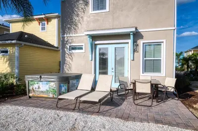 a patio with chairs and a table and a fish tank at Dreamy Cottage With Private Hot Tub Near Disney With Margaritaville Resort & Island H2O Access - 3020La in Orlando