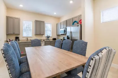 a kitchen with a wooden table and chairs at Dreamy Cottage With Private Hot Tub Near Disney With Margaritaville Resort & Island H2O Access - 3020La in Orlando
