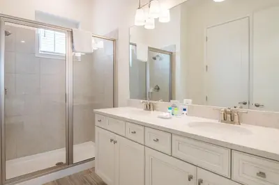 a white bathroom with a shower and a sink at Paradise Cottage With Private Pool Near Disney And Margaritaville Resort & Island H20 Waterpark Access - 7989Su in Orlando