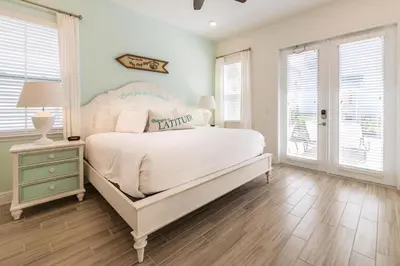 a bedroom with a white bed and a window at Tropical Oasis Cottage With Private Hot Tub Near Disney With Margaritaville Resort & Island H2O Access - 3021La in Orlando