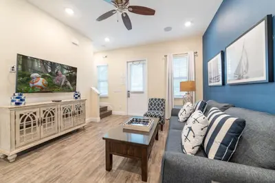 a living room with a couch and a tv at Nautical Cottage With Private Hot Tub Near Disney With Margaritaville Resort & Island H2O Access - 3044Sr in Orlando