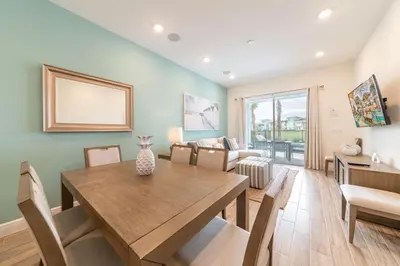 a dining room with a table and a couch at Waterfront Cottage With Private Pool Near Disney And Margaritaville Resort & Island H20 Access - 7985Su in Orlando
