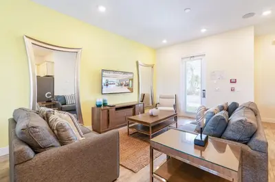 a living room with a couch and a table at Spacious Cottage With Private Pool Near Disney With Margaritaville Resort & Island H2O Access - 8009Su in Orlando