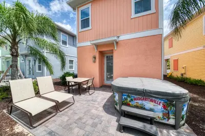 a patio with two chairs and a fish tank in front of a house at Livin In Paradise Cottage With Private Hot Tub Near Disney With Margaritaville Resort & Island H2O Access - 8076Dr in Orlando