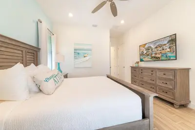 a bedroom with a large bed and a dresser at We Be Jammin Cottage With Private Hot Tub Near Disney With Margaritaville Resort & Island H2O Access - 8020Dr in Orlando