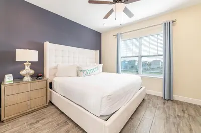 a bedroom with a white bed and a window at Fun In The Sun Cottage With Private Pool Near Disney With Margaritaville Resort & Island H2O Access - 8052Sh in Orlando