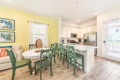 a kitchen and dining room with a table and chairs at Island Time Cottage With Hot Tub Near Disney With Margaritaville Resort & Island H2O Access - 8040Su in Orlando