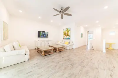 a living room with a white couch and a ceiling fan at It's All Fin & Games Cottage With Private Pool Near Disney & Margaritaville Resort & Island H20 Waterpark Access - 3090Ph in Orlando