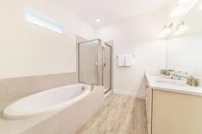 a white bathroom with a tub and a sink at It's All Fin & Games Cottage With Private Pool Near Disney & Margaritaville Resort & Island H20 Waterpark Access - 3090Ph in Orlando