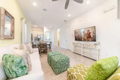 a living room with a couch and a tv at Seaweed Bay Cottage With Hot Tub Near Disney And Margaritaville Resort & Island H2O Access - 8061Dr in Orlando