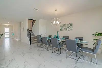 a dining room with a table and chairs at 891Pbeach Amazing Champions Gate 8 Bedroom 5 Bed Villa in Orlando
