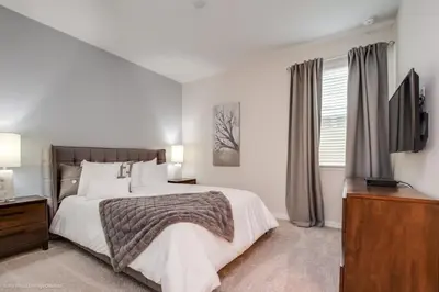 a bedroom with a large bed and a television at Solara Resort 9 Bedroom 6 Bathroom Resort Villa Villa in Orlando