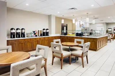 a restaurant with tables and chairs and a counter at Staybridge Suites Orlando Royale Parc Suites by IHG in Orlando