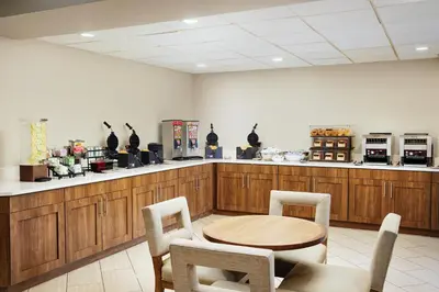 a restaurant with a table and chairs and a counter at Staybridge Suites Orlando Royale Parc Suites by IHG in Orlando