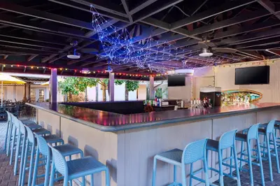a bar with blue stools at a bar at Staybridge Suites Orlando Royale Parc Suites by IHG in Orlando