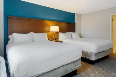 a hotel room with two beds and a blue wall at Staybridge Suites Orlando Royale Parc Suites by IHG in Orlando