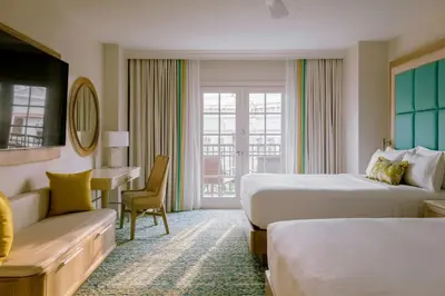 a hotel room with two beds and a desk at Gaylord Palms Resort & Convention Center in Orlando