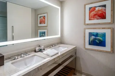 a bathroom with two sinks and a large mirror at Gaylord Palms Resort & Convention Center in Orlando