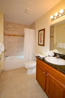 a bathroom with a sink and a toilet and a tub at Lake Buena Vista Resort Village and Spa, Near Disney in Orlando