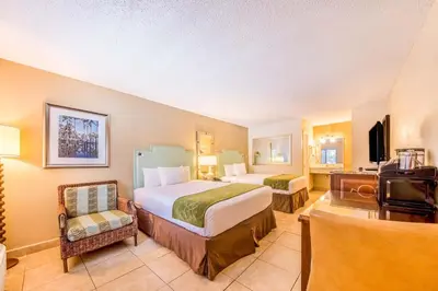 a hotel room with two beds and a television at Seasons Florida Resort in Kissimmee