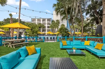 a patio with blue couches and tables and yellow pillows at Delta Hotels by Marriott Orlando Celebration in Orlando