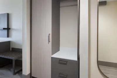 a wardrobe with a mirror in a room at Ramada Plaza by Wyndham Orlando Resort & Suites Intl Drive - Newly Renovated! in Orlando