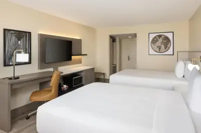 a hotel room with two beds and a television at Ramada Plaza by Wyndham Orlando Resort & Suites Intl Drive - Newly Renovated! in Orlando