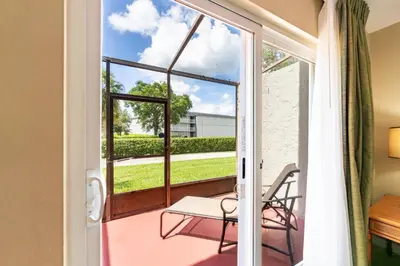 a door to a balcony with a chair and a window at FantasyWorld Resort in Kissimmee