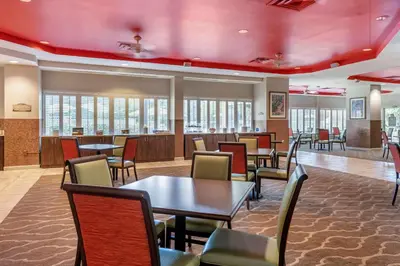 a waiting room at a hospital with tables and chairs at Comfort Suites Maingate East in Orlando