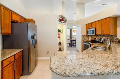 a kitchen with a sink and a refrigerator at #503 Stunning 4 Bed, 3 bath villa with southwest facing pool and spa in Orlando