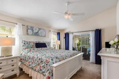 a bedroom with a bed and a ceiling fan at #503 Stunning 4 Bed, 3 bath villa with southwest facing pool and spa in Orlando