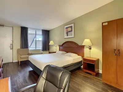 a hotel room with a bed and a chair at Stayable Orlando at Florida Mall in Orlando
