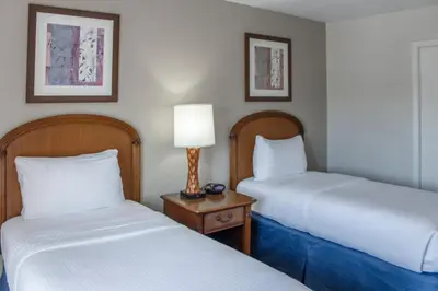 a room with two beds and a lamp on a table at Hilton Vacation Club Polynesian Isles Kissimmee in Kissimmee
