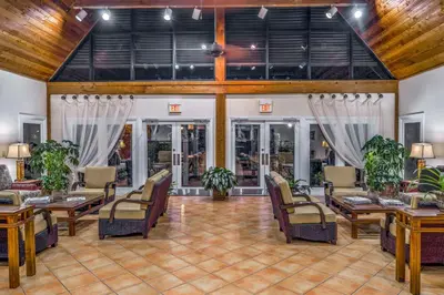 a lobby with chairs and tables and windows at Hilton Vacation Club Polynesian Isles Kissimmee in Kissimmee