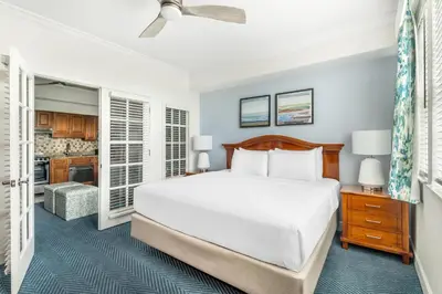 a bedroom with a large bed and a kitchen at Hilton Vacation Club Grand Beach Orlando in Orlando