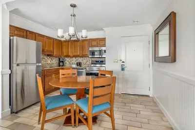a kitchen with a table and chairs and a refrigerator at Hilton Vacation Club Grand Beach Orlando in Orlando