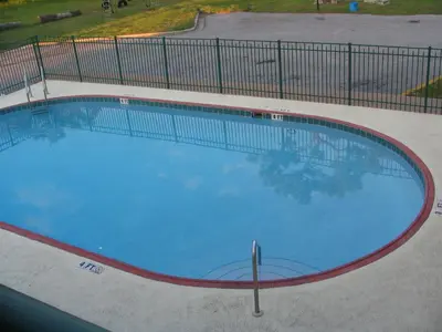 a large swimming pool in a parking lot at Ambassador Inn in Kissimmee