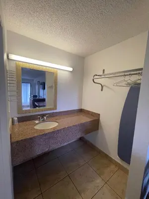 a bathroom with a sink and a mirror at Ambassador Inn in Kissimmee