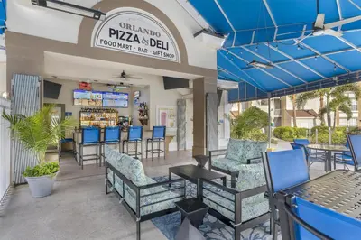 a patio at a restaurant with blue chairs and tables at Hilton Vacation Club Grande Villas Orlando in Orlando