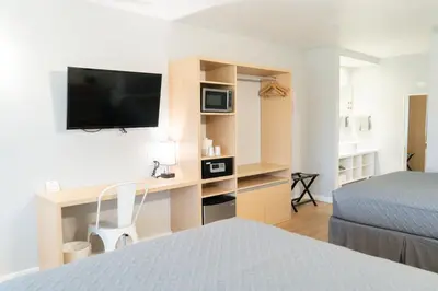 a hotel room with a desk with a bed and a tv at Disney 12 minutes for family, Pool and parking FREE in Kissimmee
