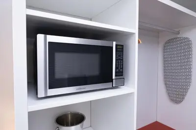 a microwave oven on a shelf in a kitchen at Disney 12 minutes for family, Pool and parking FREE in Kissimmee