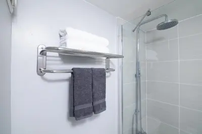 a bathroom with a towel rack and a shower at Disney 12 minutes for family, Pool and parking FREE in Kissimmee