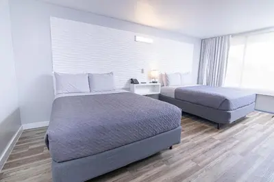 a hotel room with two beds and a window at Disney 12 minutes for family, Pool and parking FREE in Kissimmee