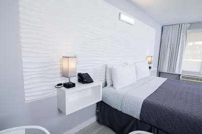 a hotel room with a bed and a lamp on a night stand at Disney 12 minutes for family, Pool and parking FREE in Kissimmee