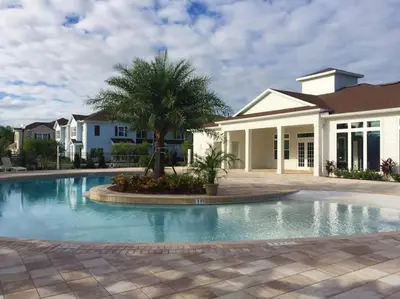 a swimming pool in front of a house at Amazing Townhouse in gated community 10' to Disney! in Kissimmee