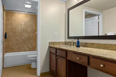 a bathroom with a sink and a toilet and a mirror at Club Wyndham Cypress Palms in Kissimmee