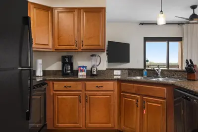 a kitchen with wooden cabinets and a sink at Club Wyndham Bonnet Creek in Orlando